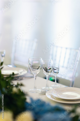 Sparkling glassware stands on long table prepared for wedding