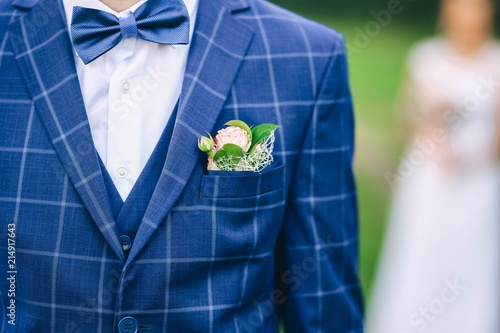blue bridegroom's wedding suit with a butterfly and a boutonniere.