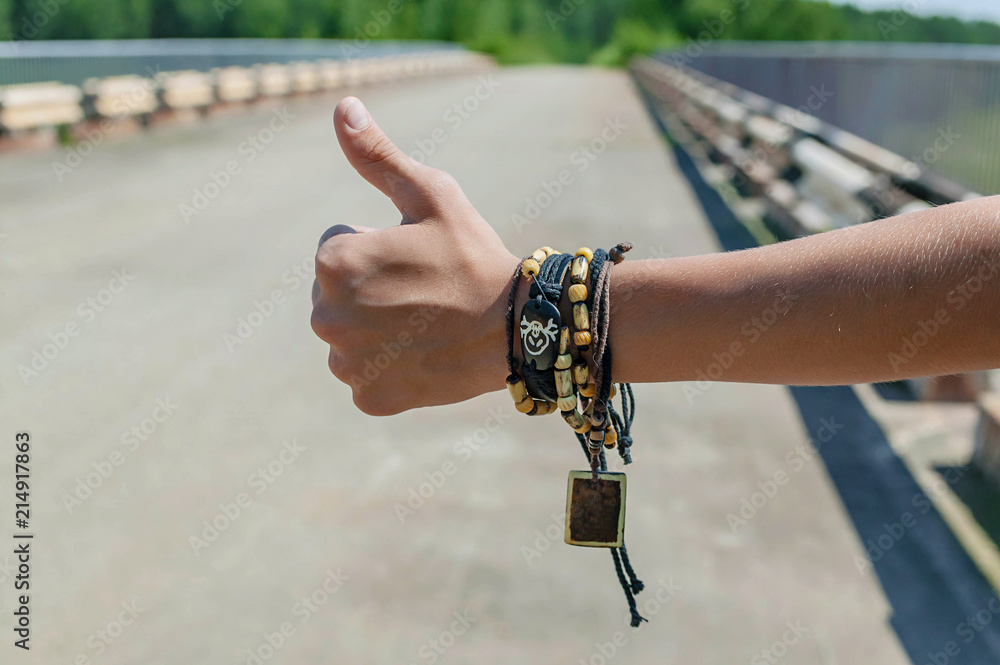 Hand hitchhiking for travel concept. Close-Up. Freeway background
