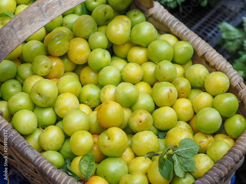 fresh green plums in the newly collected basket
