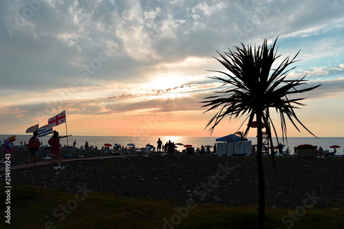 Beautiful sunset over the Black sea. Beach with palm trees in Batumi, Georgia