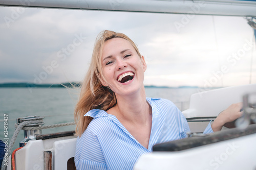 Young adult Caucasian female enjoys her day on a sail boat yacht