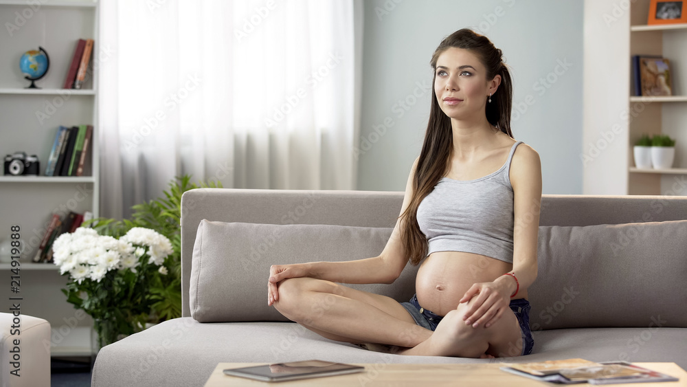 Pregnant lady doing yoga breathing exercises, relaxing at home, health care Pregnant lady doing yoga breathing exercises, relaxing at home, health care