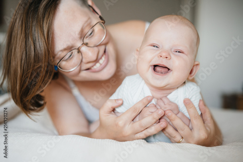 In the morning in bed a portrait of the mother and baby of the newborn with emotions of happiness and joy.