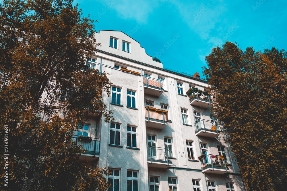 Naklejka premium white residential building at berlin framed by green trees