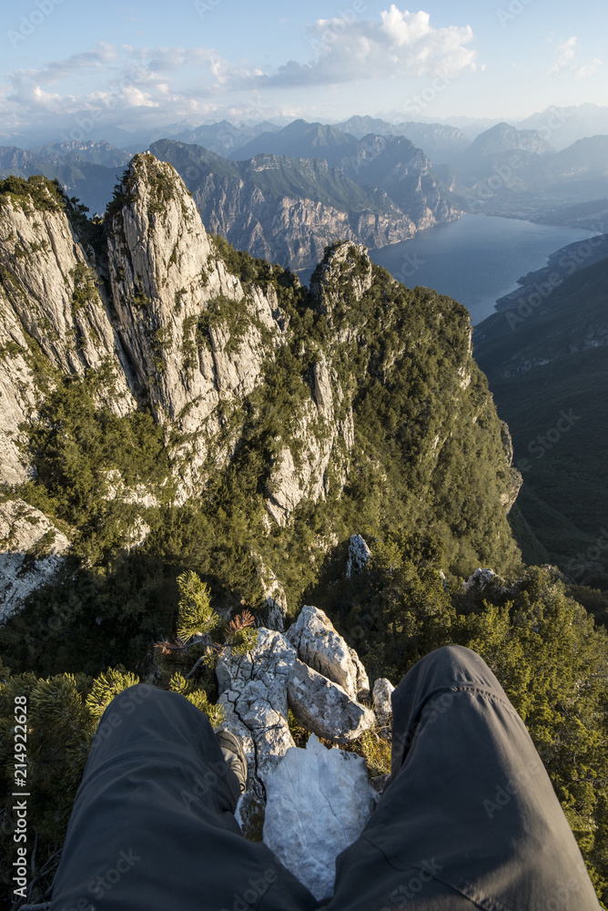 Fototapeta premium Pov sitting on the odge of a cliff in high mountain