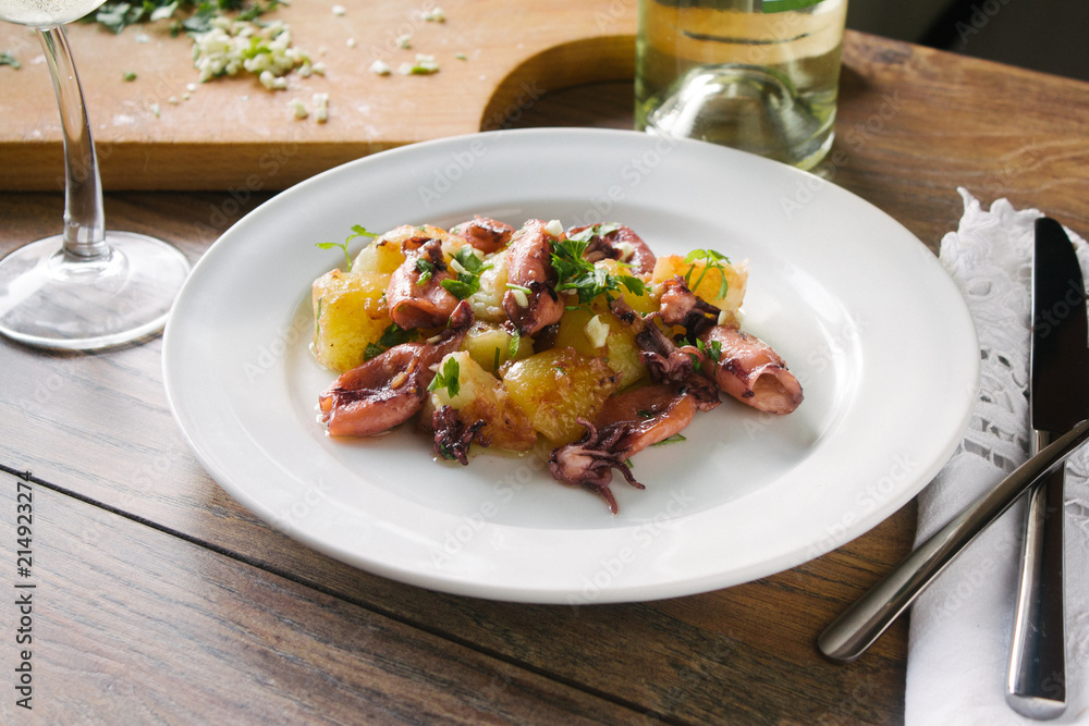 Alluring dish made of grilled squid and baked potatoes. Close up. Alluring dish made of grilled squid and baked potatoes. Close up.