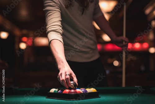 Man holding snooker ball from triangle rack photo