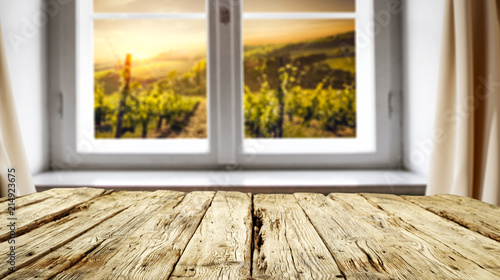 Retro old wooden table with free space for your decoration and rural window background. 