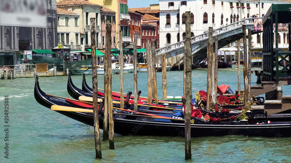 Beautiful gondolas docked in Venice Canal, water transport, sightseeing tour