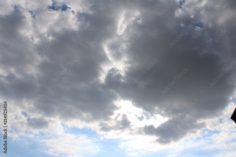 Visible sun shining through dark cloud on bright day