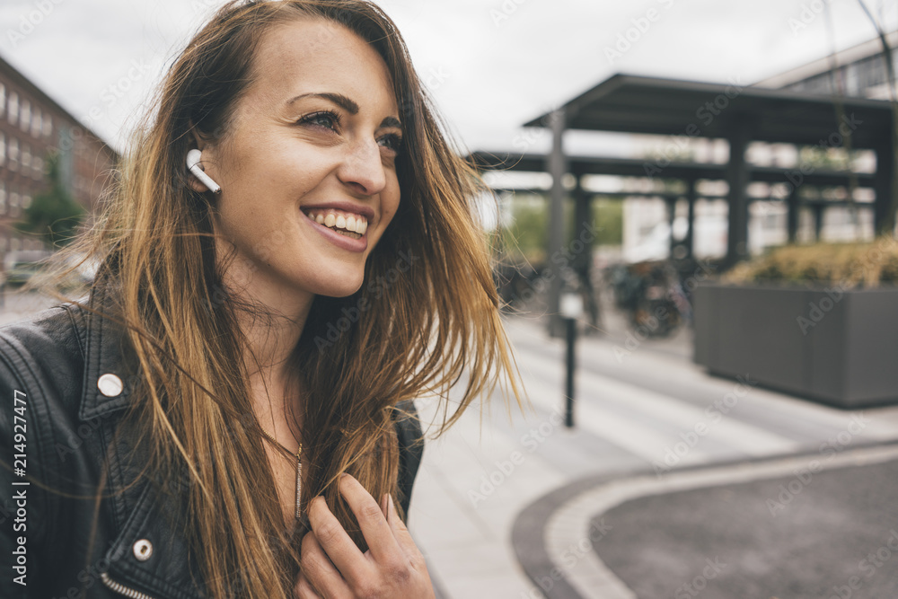© Westend61 - Smiling young woman wearing in-ear phones © Westend61 - Smiling young woman wearing in-ear phones