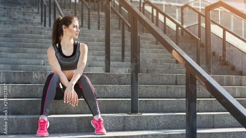 Tired young woman relaxing on stairs