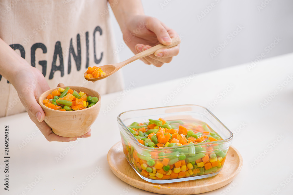 Ladle of steamed freshly harvested young vegetables including crinkle cut sliced carrots, peas and potato for a healthy accompaniment to dinner Ladle of steamed freshly harvested young vegetables including crinkle cut sliced carrots, peas and potato for a healthy accompaniment to dinner