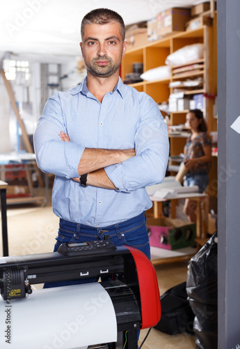 portrait of male employee at print shop in an atelier for production of advertising