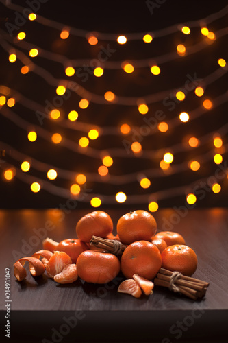 Mandarins and Cinnamon on Background of Blurred Defocused Multicolor Lights