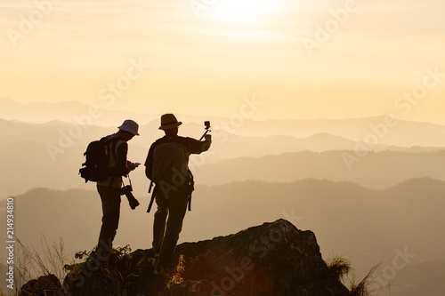 Silhouette of man hold up hands on the peak of mountain,success concept © freedom_naruk