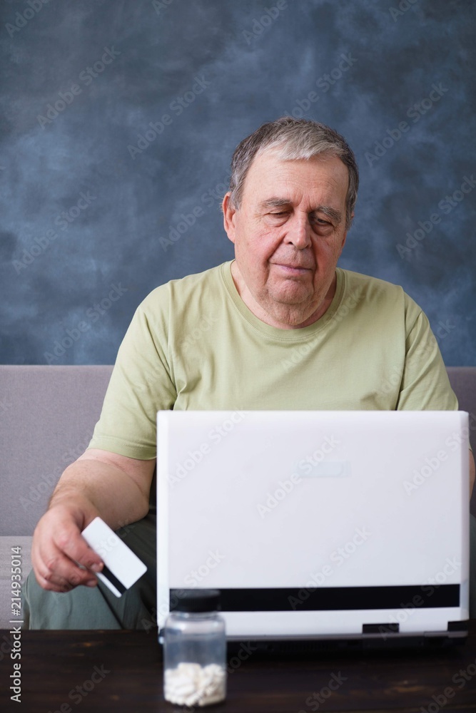 Internet, online banking, payment innovation technology and people concept. Senior man with credit card paying bills at laptop Internet, online banking, payment innovation technology and people concept. Senior man with credit card paying bills at laptop