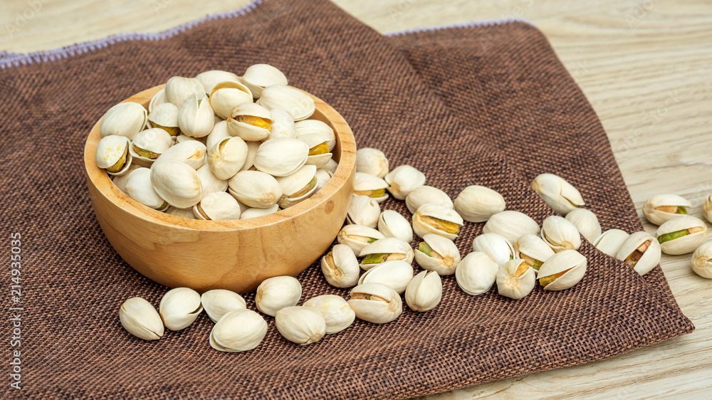 Pistachio nuts on a wooden table.