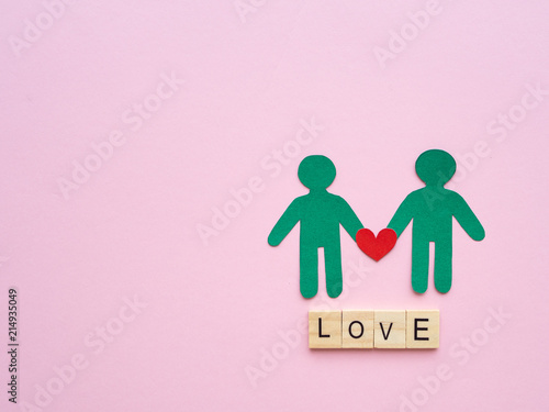 Male couple paper with red heart and LOVE text wooden block on pink background. Love  LGBT  gay pride  homosexual  valentines day concept.