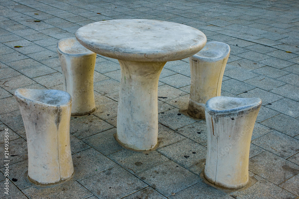 Stone table and four chairs in the street, Tel Aviv, Israel Stone table and four chairs in the street, Tel Aviv, Israel
