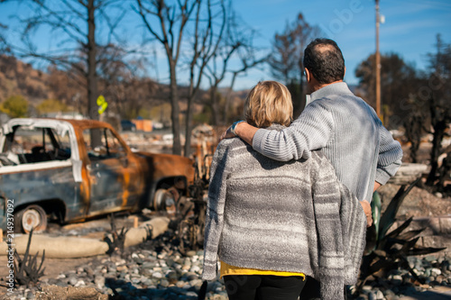 Valokuva Man and his wife owners, checking burned and ruined of their house and yard after fire, consequences of fire disaster accident