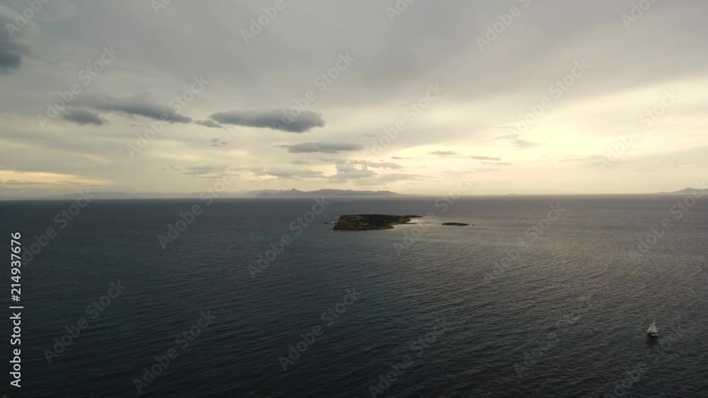 Flying over a small island on a cloudy day in Greece. Sunset on the horizon. Flying over a small island on a cloudy day in Greece. Sunset on the horizon.