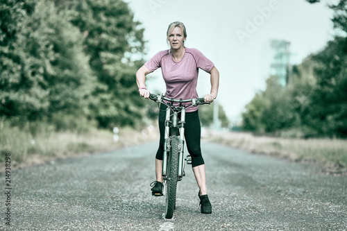 Frau mit Mountainbike im Wald unterwegs