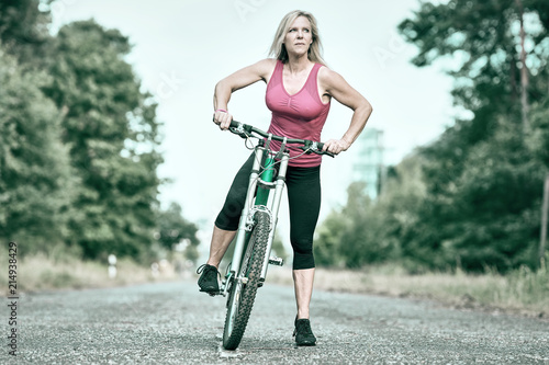 Frau mit Mountainbike im Wald unterwegs