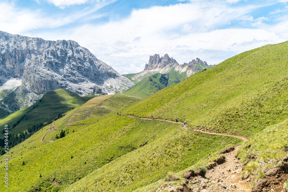 Italian Dolomites Landscape. Light after rain in Dolomites. Rocky peaks in the background surrounded by rain clouds. Mountain valley with layers of forest and mountains. Aerial view path trail hikeing