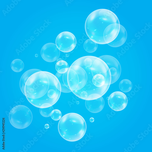 Realistic soap bubbles with rainbow reflection set isolated on the blue background.