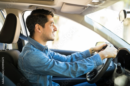 Картината върху платно Young guy driving a car carefully