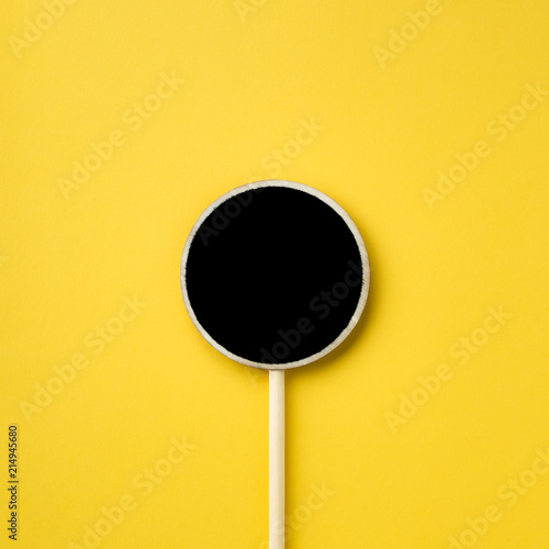 Wooden information label sign with black empty place for text, Blank blackboard label isolated on yellow  background, Top view and copy space.
