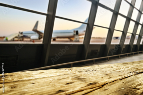 Wooden desk of free space and airport background with big window 