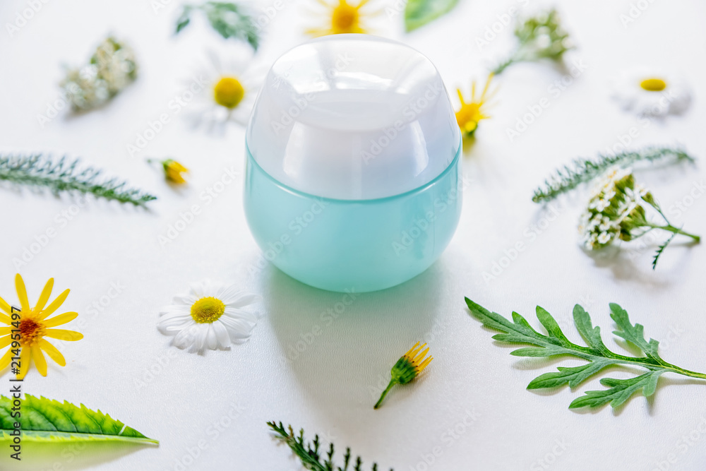 container with cosmetic on white background with field flowers and leaves. The concept of summer and idea for advertisement of cream. Flatlay. container with cosmetic on white background with field flowers and leaves. The concept of summer and idea for advertisement of cream. Flatlay.