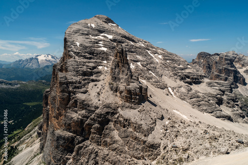 Climbers silhouette standing on a cliff in Dolomites. Tofana di Mezzo  Punta Anna  Italy. Man Celebrate success on top of the mountain Hiker standing on rocky ridge and enjoying  the view in Dolomites