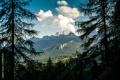 Italian Dolomites landscape. . Rocky peaks in the background surrounded by Natural Spruce Tree Forest. Layers of forest and mountains ridge. Rocky Mountains Dolomiti. Sunny day