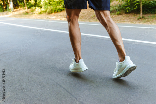 Back view of muscular sportsman legs jogging