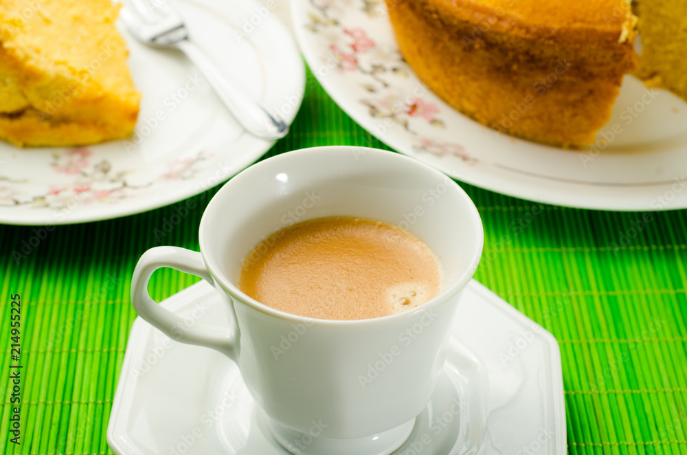 Coffee cup with cornmeal cake in the background Coffee cup with cornmeal cake in the background