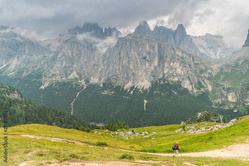  Italian Dolomites landscape. Light after rain in Dolomites. Rocky peaks in the background surrounded by rain clouds. Layers of forest and mountains ridge.  Rocky Mountains Dolomiti. Storm rain over r