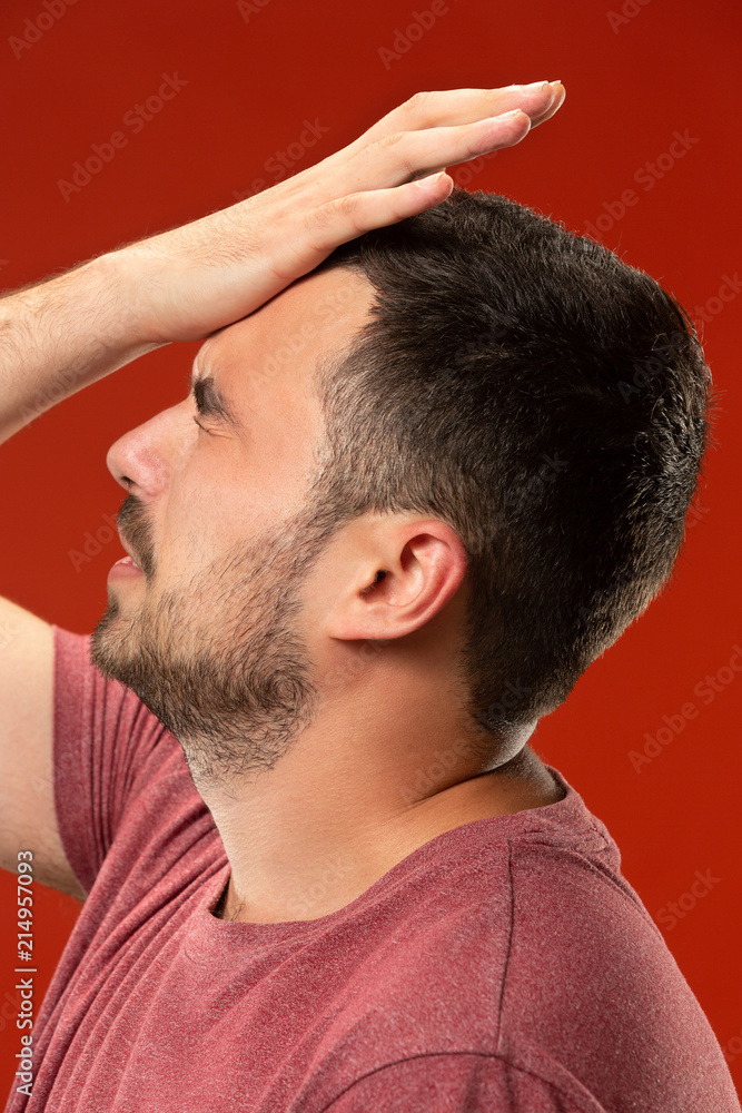 Obraz premium Beautiful man looking suprised and bewildered isolated on red