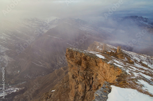 At the edge of cliff. View of canyon and river, mountain range and ancient aul Goor with defensive and military towers. Nature and travel. Russia, North Caucasus, Dagestan, Shamilsky District photo