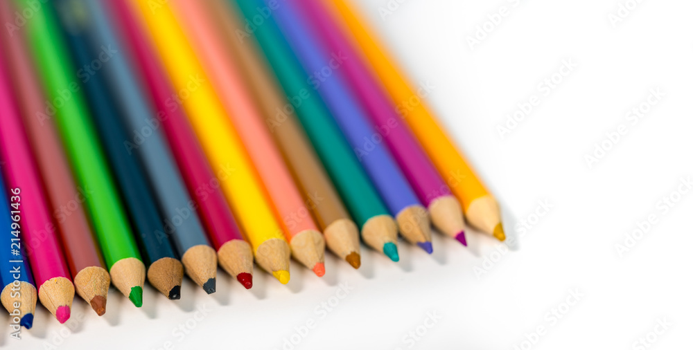 Close up of row of colorful drawing pencils against white Close up of row of colorful drawing pencils against white
