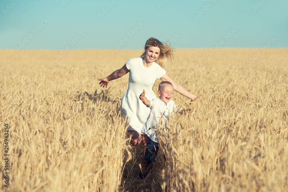 Mom and little son are running around the wheat field. Mom and little son are running around the wheat field.