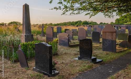 Graveyard of St. Nidan's Church at sunset photo