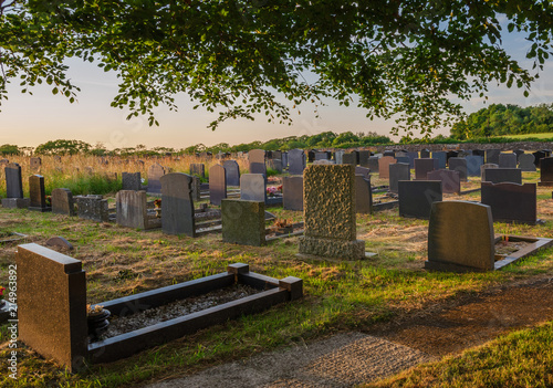 Graveyard of St. Nidan's Church at sunset photo