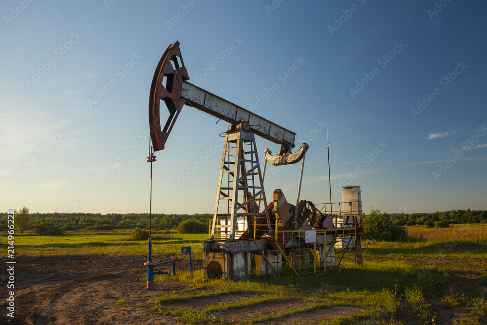 The oil pump, industrial equipment. Oil rocking at sunset in Russia, Republic of Bashkortostan The oil pump, industrial equipment. Oil rocking at sunset in Russia, Republic of Bashkortostan