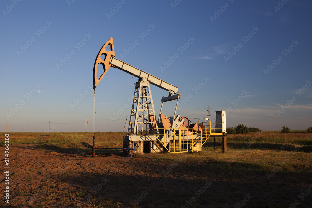 The oil pump, industrial equipment. Oil rocking at sunset in Russia, Republic of Bashkortostan The oil pump, industrial equipment. Oil rocking at sunset in Russia, Republic of Bashkortostan