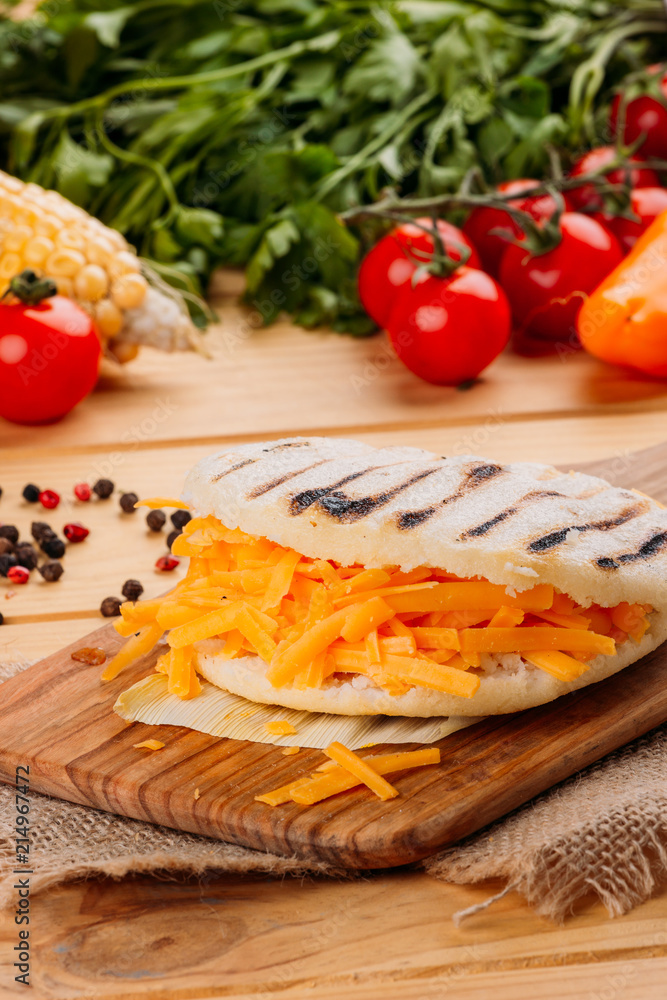 Arepa with cheddar cheese on a cutting board Arepa with cheddar cheese on a cutting board