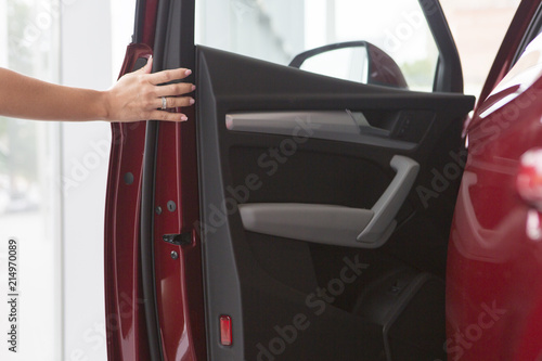 Woman hand on open the new red car door background © biggur